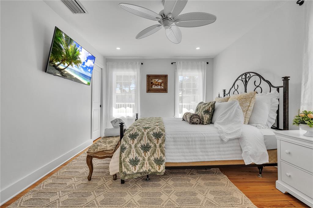 8241 Main Street Bokeelia, FL 33922 - Photo 76 of 100 a bedroom with a bed and a chandelier