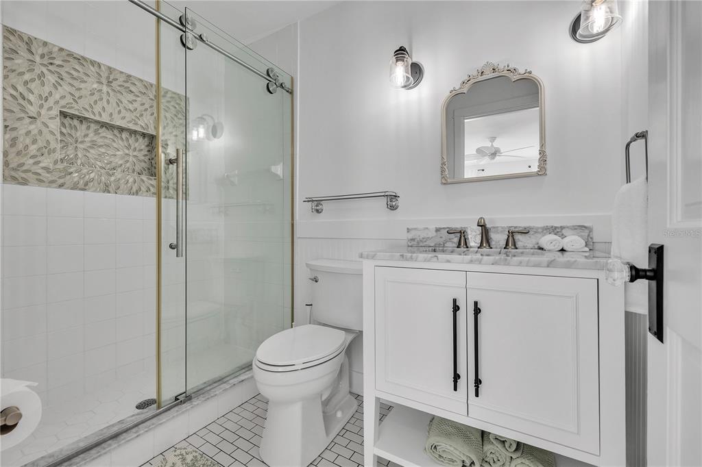 8241 Main Street Bokeelia, FL 33922 - Photo 77 of 100 a bathroom with a granite countertop sink toilet and shower