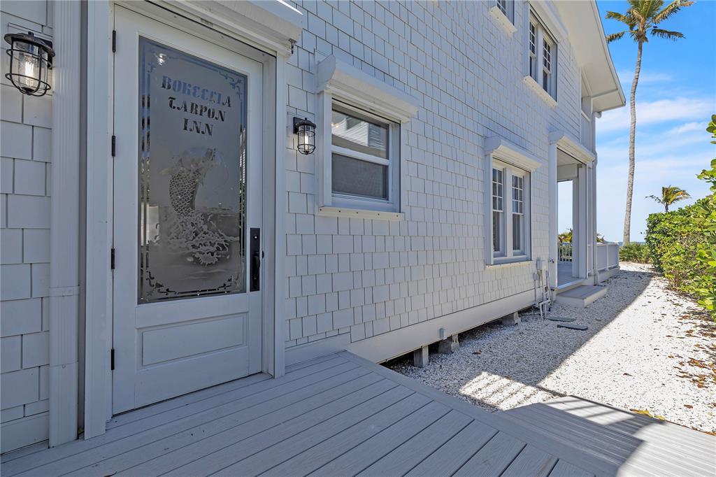 8241 Main Street Bokeelia, FL 33922 - Photo 82 of 100 a view of front door and porch with wooden floor