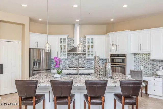 a bed sitting in a bedroom next to a window with a lamp on table