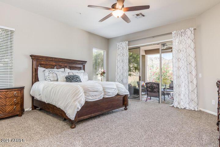 16715 North 108th Way Scottsdale, AZ 85255 - Photo 45 of 104 a bed sitting in a bedroom next to a window and a chandelier