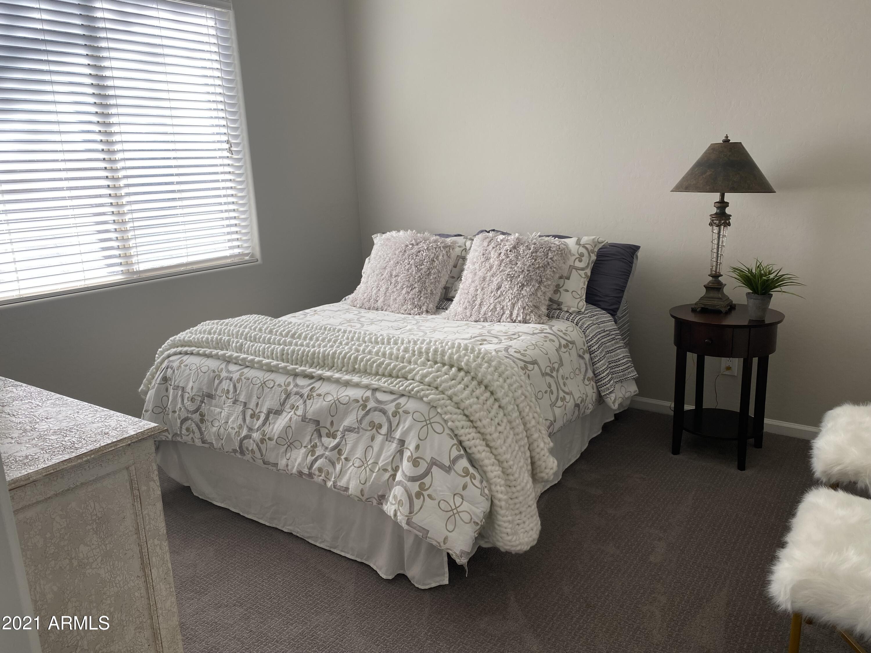 16715 North 108th Way Scottsdale, AZ 85255 - Photo 53 of 104 a bed sitting in a bedroom next to a window with a lamp on table