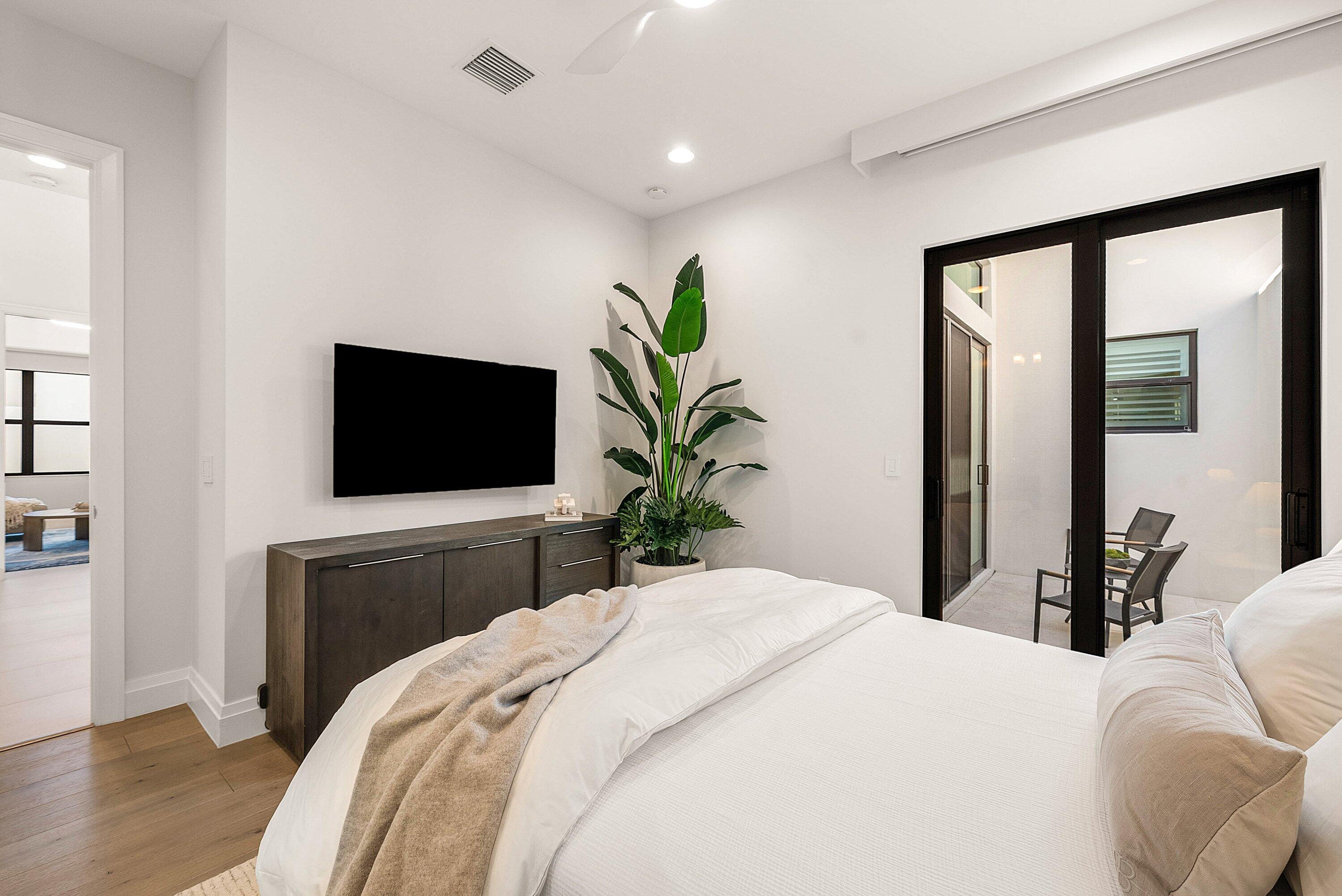 17135 Abruzzo Avenue Boca Raton, FL 33496 - Photo 49 of 95 a bedroom with a large bed and a flat screen tv