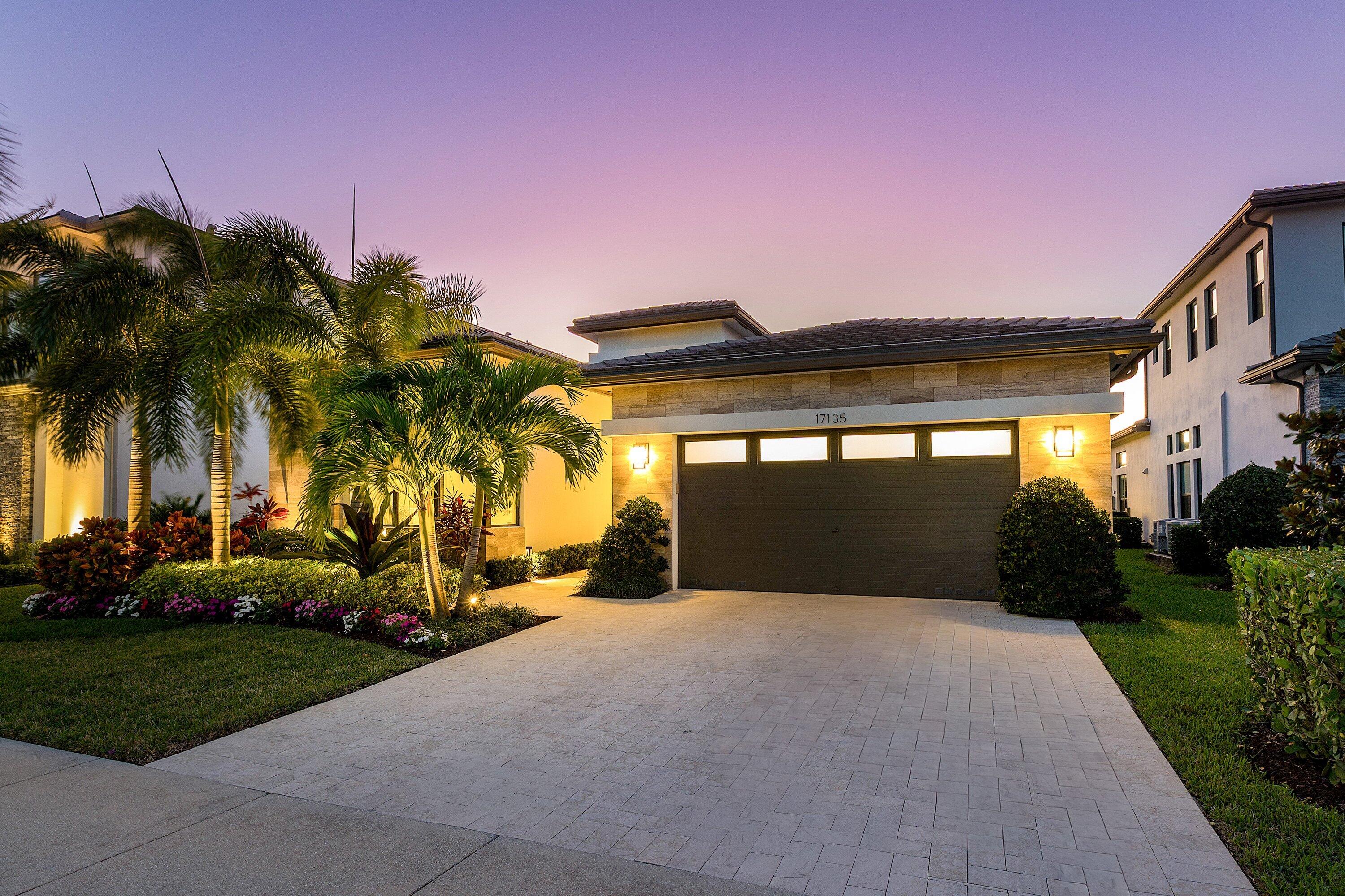 17135 Abruzzo Avenue Boca Raton, FL 33496 - Photo 66 of 95 a front view of a house with a yard and palm trees