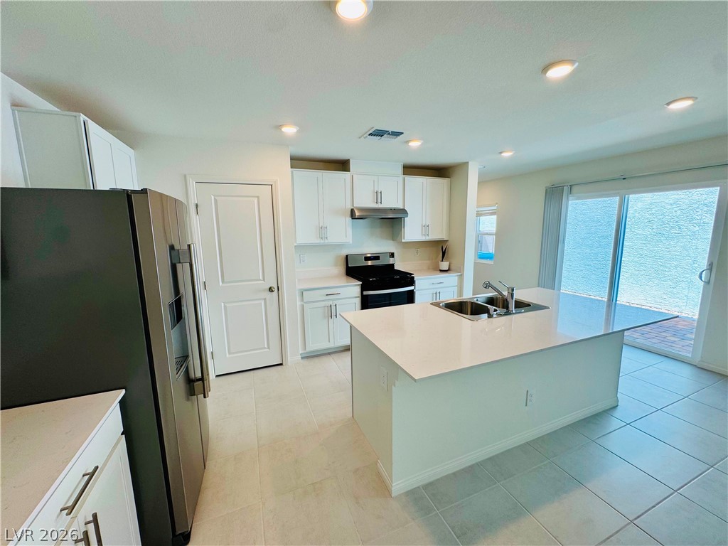 9249 Innot Avenue Las Vegas, NV 89148 - Photo 5 of 24 A contemporary kitchen space boasts a central island and sleek stainless steel appliances.