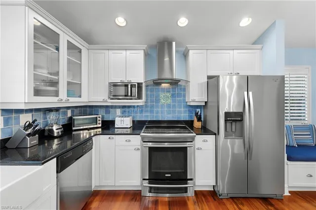 a kitchen with stainless steel appliances a refrigerator a stove a sink and a hard wood floors