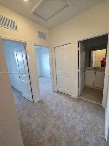 an empty room with mirror and entrance