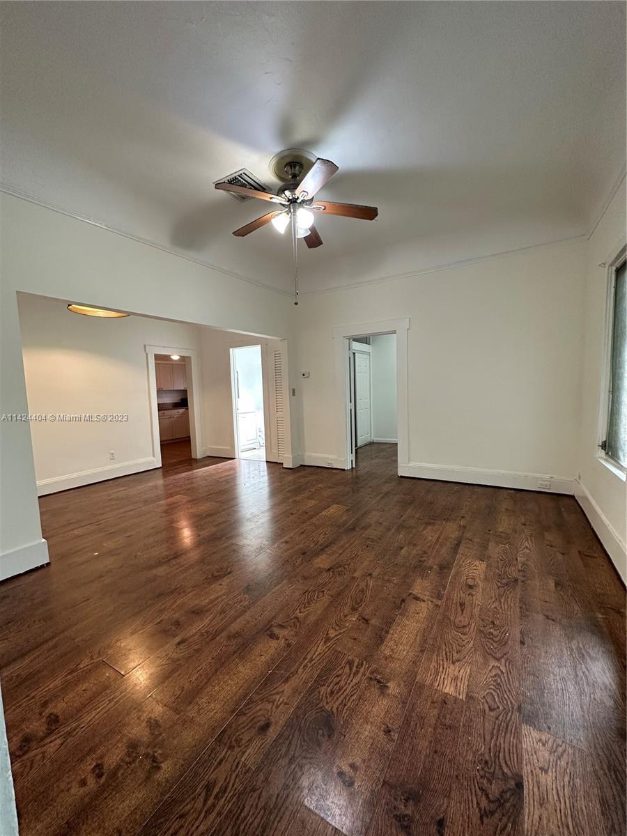 a view of empty room with wooden floor