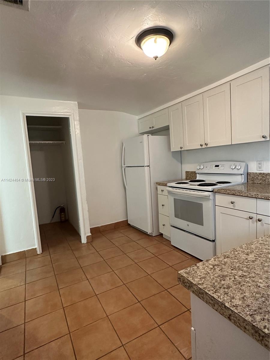 2430 Southwest 25th Terrace, Unit A Miami, FL 33133 - Photo 12 of 19 a kitchen with a stove top oven and cabinets