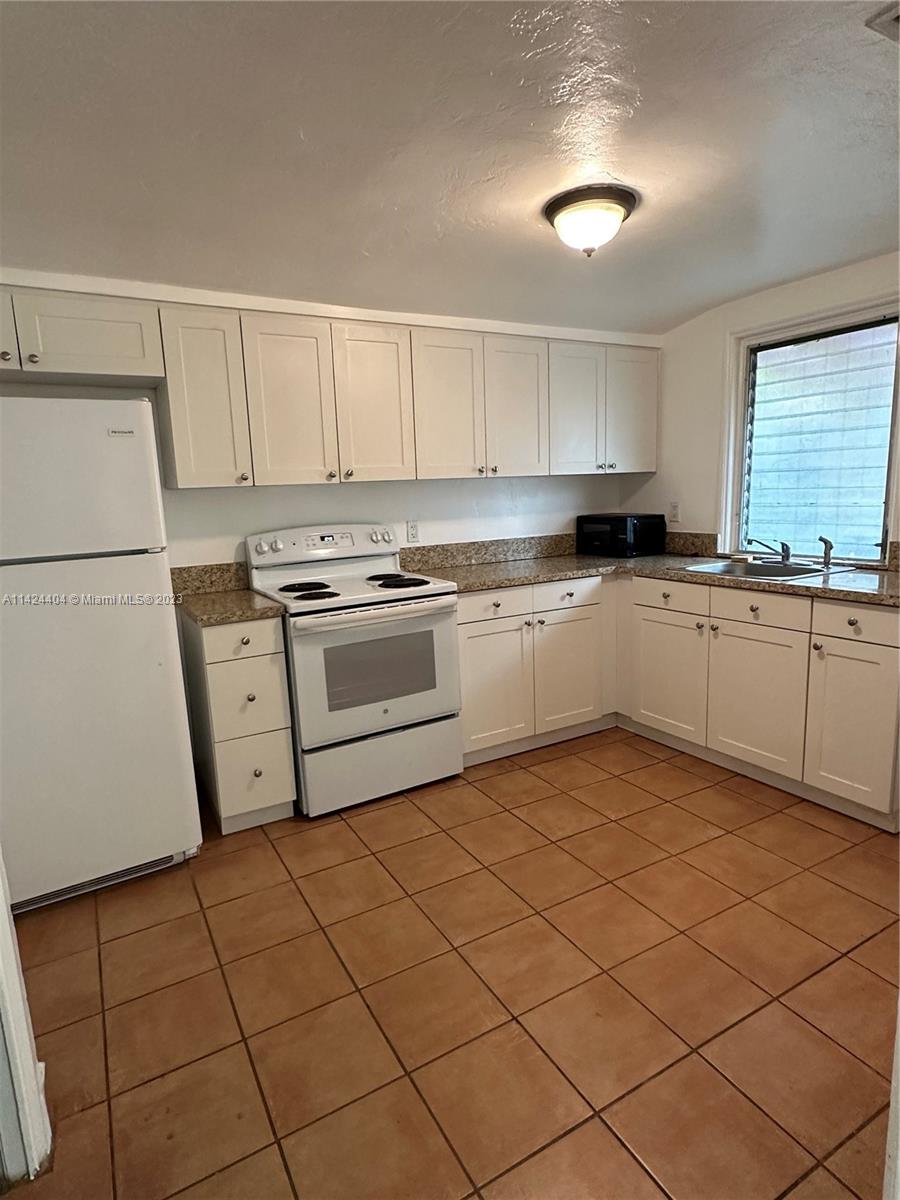 2430 Southwest 25th Terrace, Unit A Miami, FL 33133 - Photo 4 of 19 a kitchen with a cabinets a sink and appliances