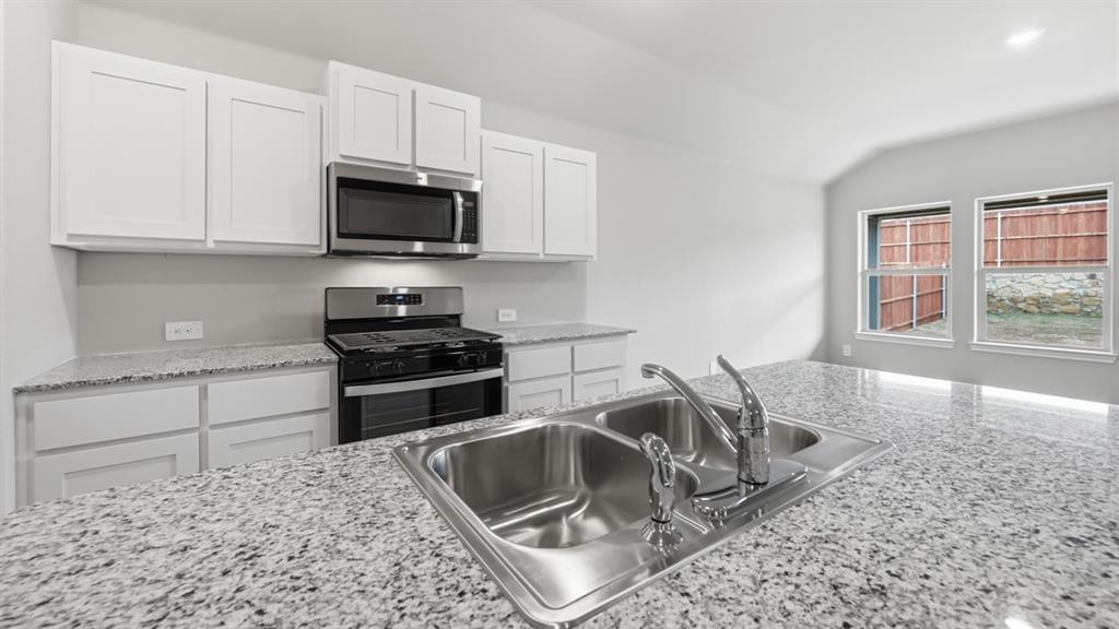 1920 Cherokee Lane Cleburne, TX 76033 - Photo 2 of 34 a kitchen with granite countertop a sink and a stove top oven