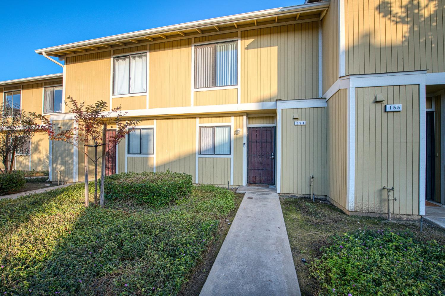 4885 North Backer Avenue, Unit 154 Fresno, CA 93726 - Photo 3 of 17 a front view of a house with garden