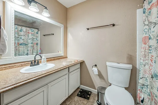 a bathroom with a granite countertop toilet sink and mirror
