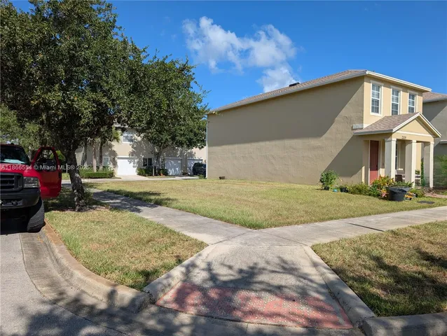 a view of a white house with a yard