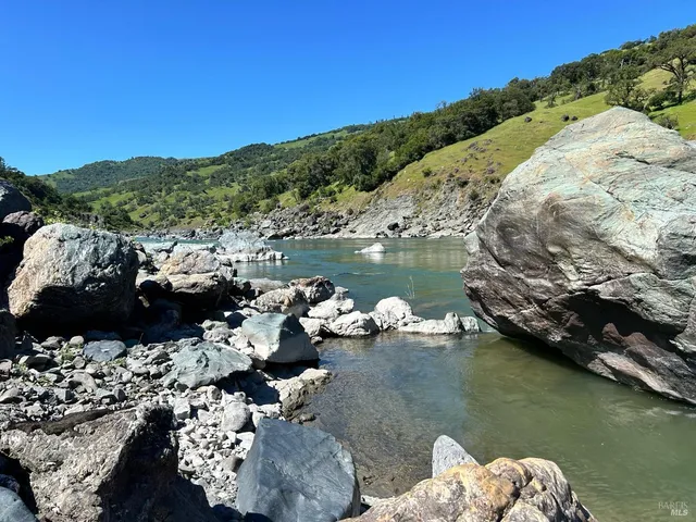 a view of a grassy field with trees in the background