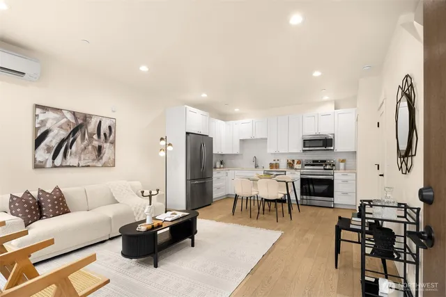 a living room with stainless steel appliances lots of furniture and kitchen view