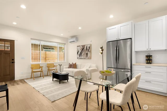 a living room with furniture a large window and stainless steel appliances