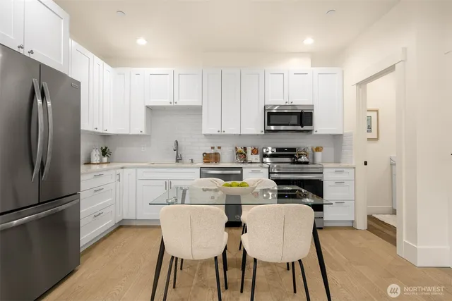 a kitchen with a refrigerator a stove a microwave and white cabinets