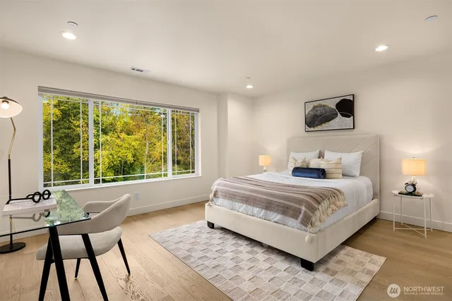 a bedroom with a bed and large windows