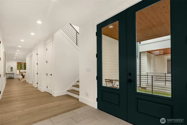 a view of a hallway with wooden floor and a living room