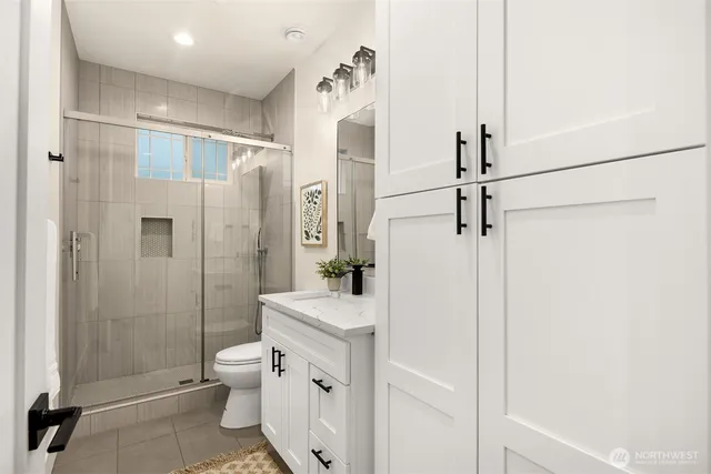 a bathroom with a sink a toilet and shower