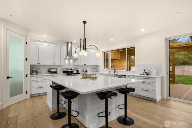 a kitchen with kitchen island a stove a table and chairs in it
