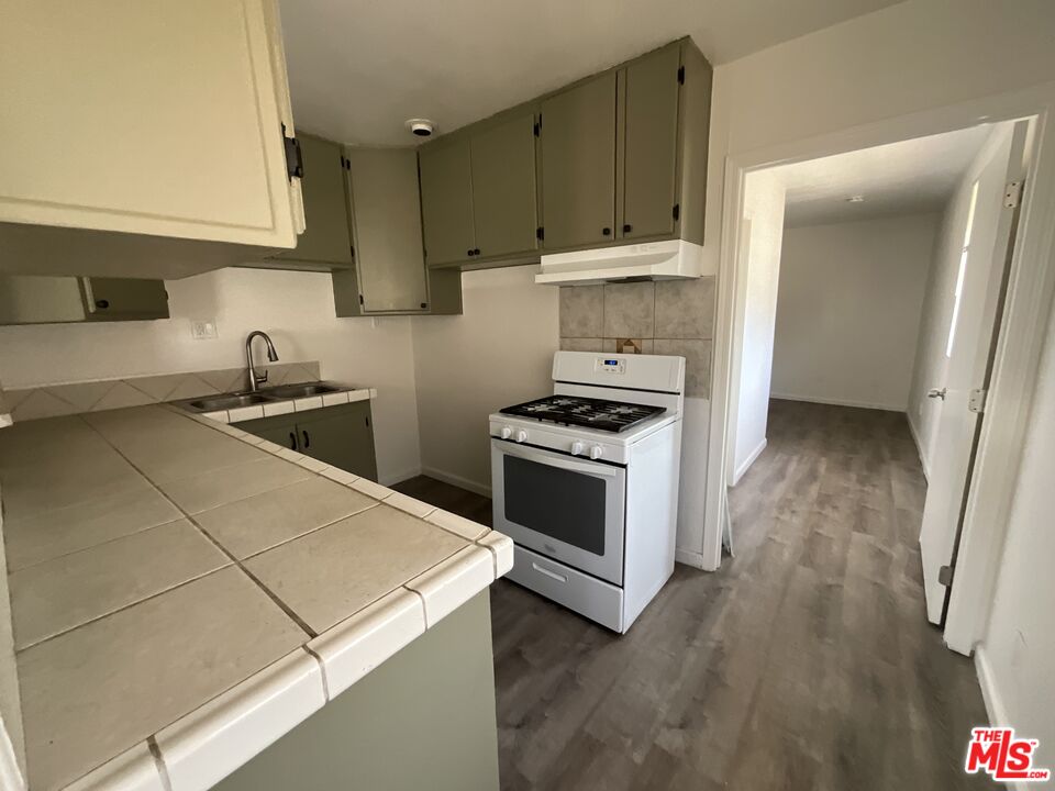 1324 North Mt Vernon Avenue Colton, CA 92324 - Photo 4 of 8 a kitchen with granite countertop a stove and a sink
