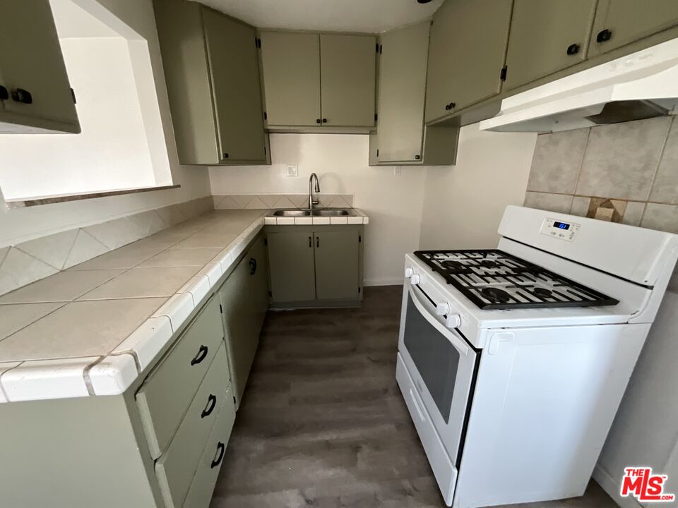 1324 North Mt Vernon Avenue Colton, CA 92324 - Photo 5 of 8 a kitchen with sink a stove and cabinets