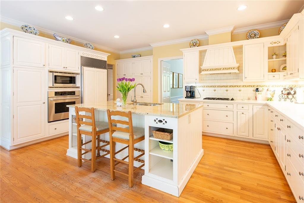 2785 Arden Road Northwest Atlanta, GA 30327 - Photo 10 of 34 a kitchen with stainless steel appliances kitchen island granite countertop a stove a sink and white cabinets with wooden floor