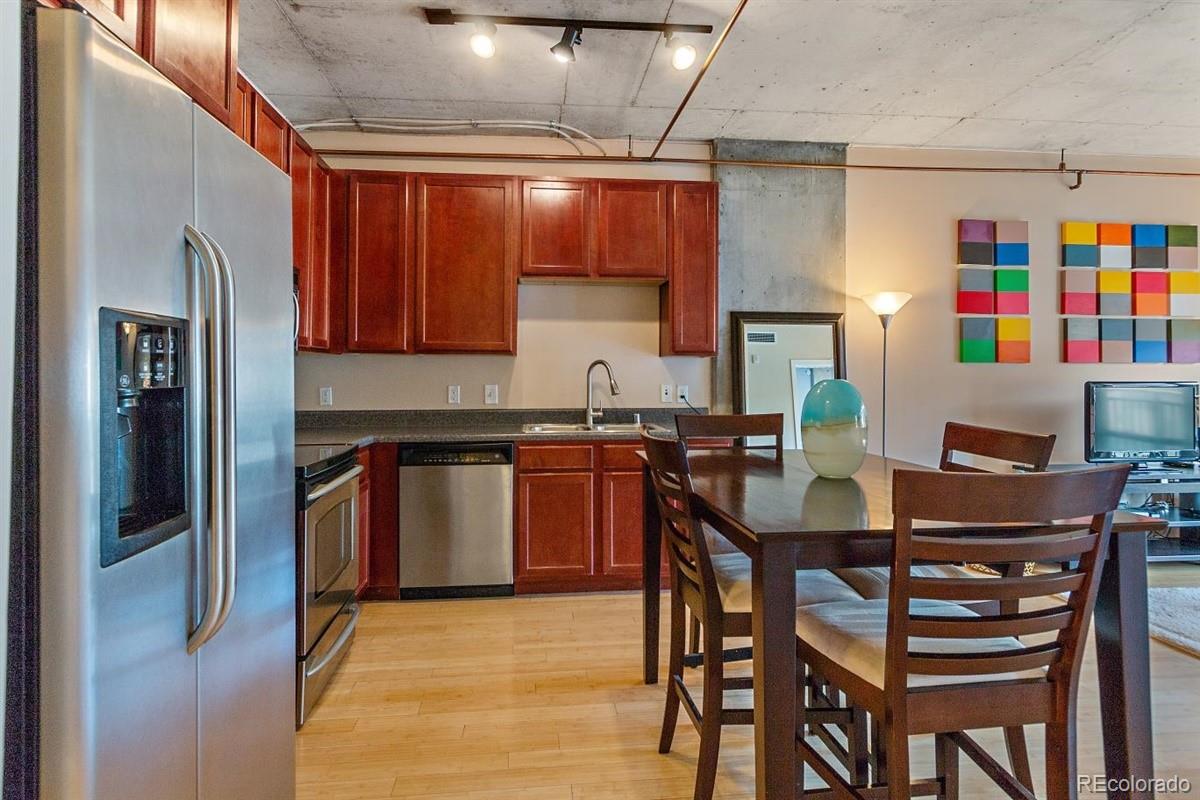 1475 Delgany Street, Unit 307 Denver, CO 80202 - Photo 7 of 18 a dining room with a wooden table and chairs
