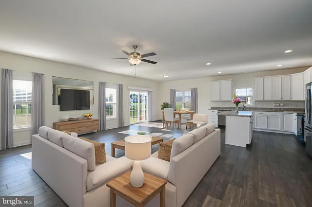 a living room with furniture kitchen and a flat screen tv