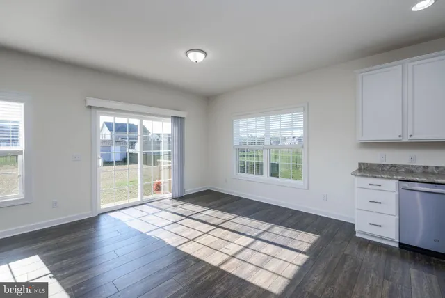 a view of kitchen with granite countertop window and wooden floor