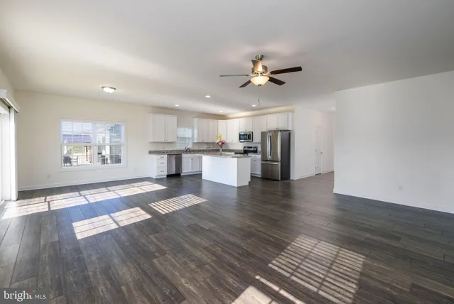 a view of empty room with wooden floor and window