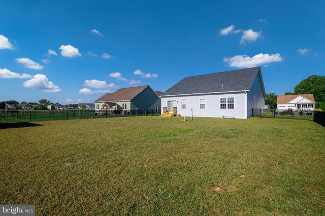 a front view of house with yard and lake view in back