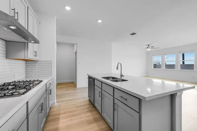 a kitchen with a sink stove and cabinets
