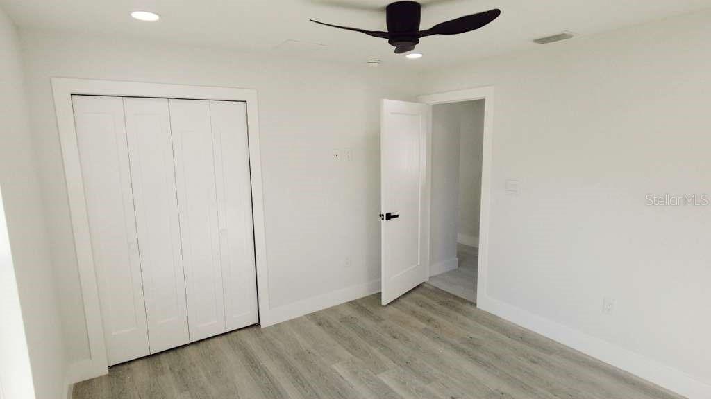 4115 El Rado Avenue Sebring, FL 33872 - Photo 12 of 31 an empty room with wooden floor cabinet and a ceiling fan