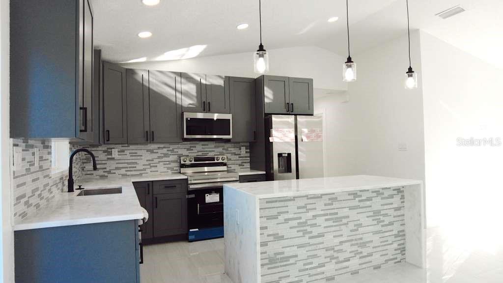 4115 El Rado Avenue Sebring, FL 33872 - Photo 6 of 31 a kitchen with kitchen island a sink stainless steel appliances and cabinets
