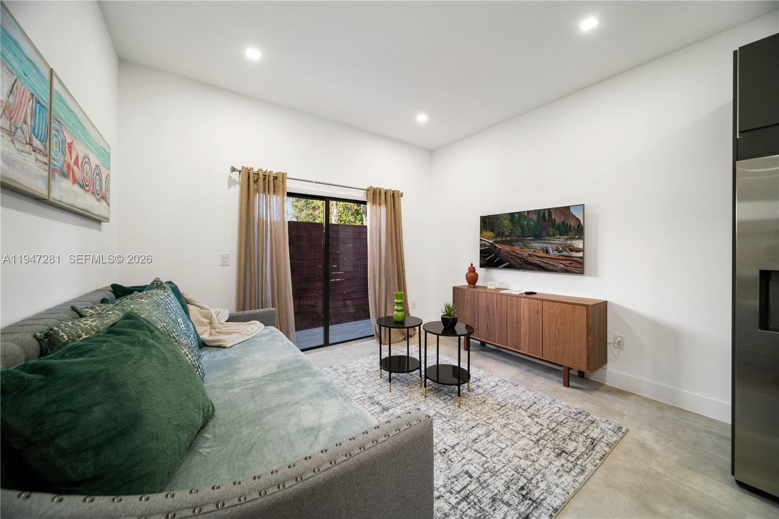 95 Northwest 52nd Street Miami, FL 33127 - Photo 15 of 27 a living room with furniture and a flat screen tv
