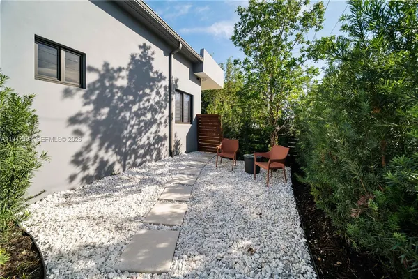 a backyard of a house with table and chairs
