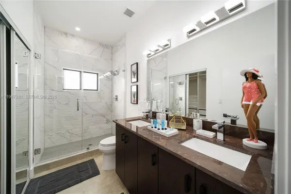 a bathroom with a double vanity sink mirror and toilet