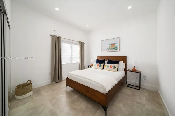 a bed sitting in a bedroom next to a window