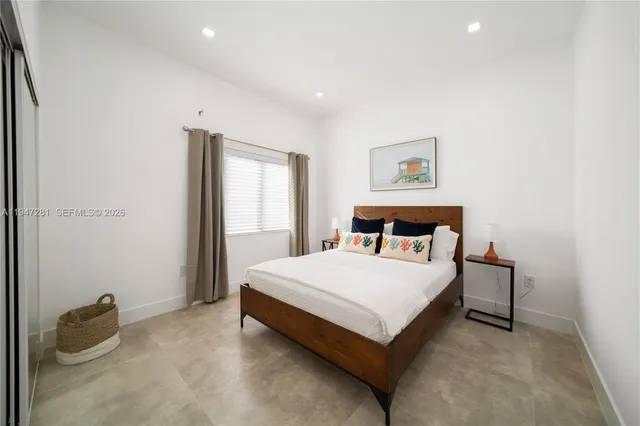 a bed sitting in a bedroom next to a window