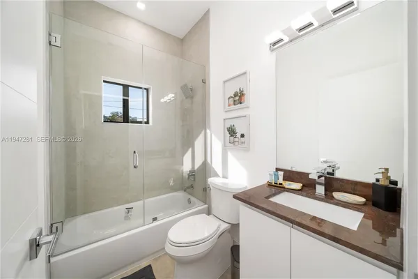 a bathroom with a granite countertop sink a toilet and a bathtub