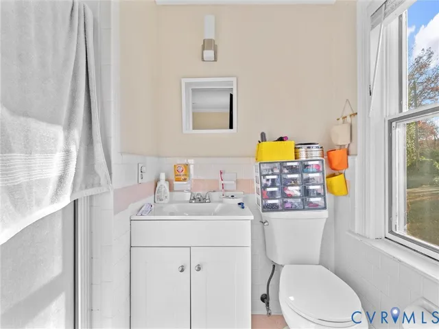 a bathroom with a toilet a sink and a window