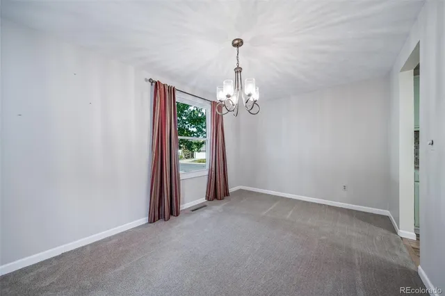 a view of a chandelier in big room and a mirror