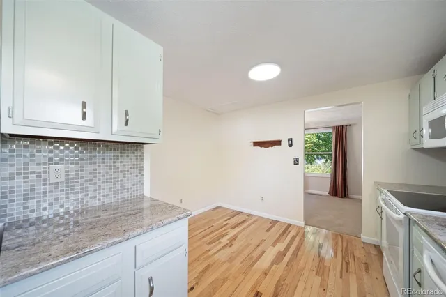 a kitchen with granite countertop white cabinets and sink