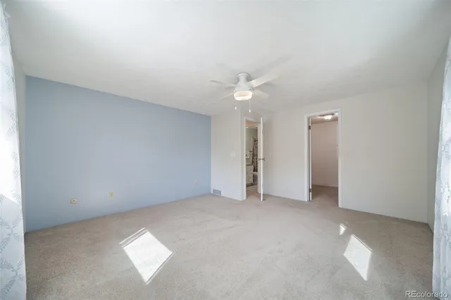 an empty room with a ceiling fan and a window