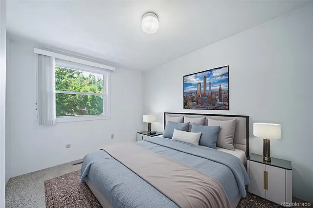 a bedroom with a bed and a painting on the wall