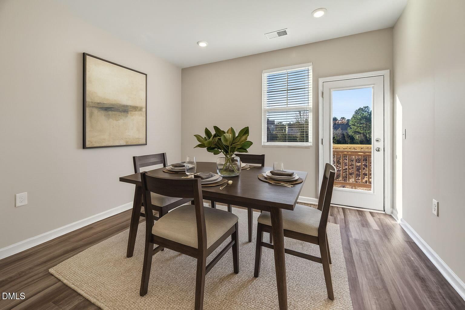 1063 Shoreside Drive Durham, NC 27713 - Photo 16 of 35 a view of a dining room with furniture window and wooden floor