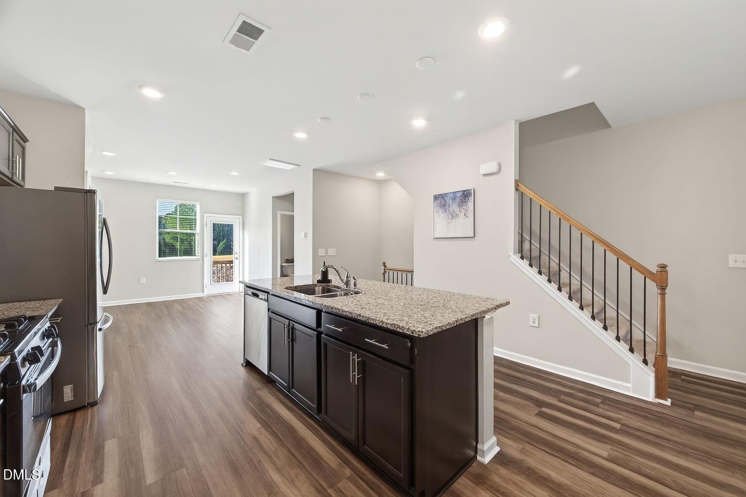1063 Shoreside Drive Durham, NC 27713 - Photo 19 of 35 a kitchen with stainless steel appliances granite countertop a stove and a refrigerator